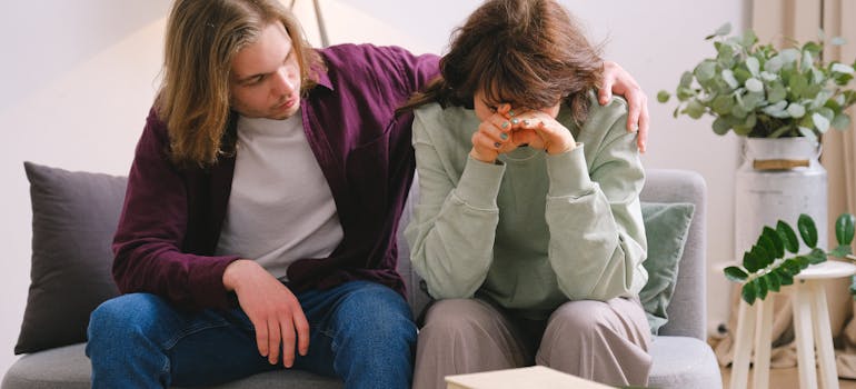 Man supporting his wife who is trying to prepare for rehab.
