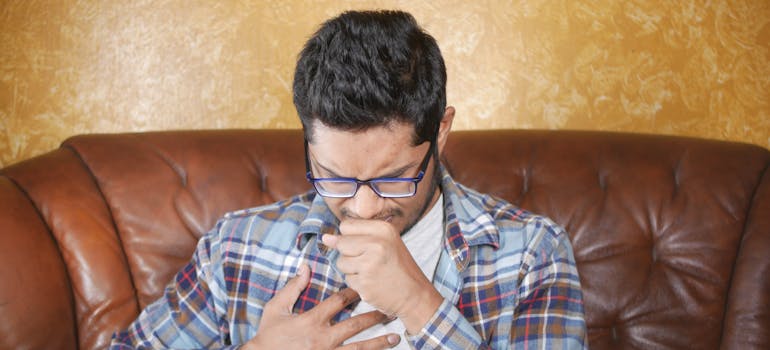 Man coughing because of vape use.