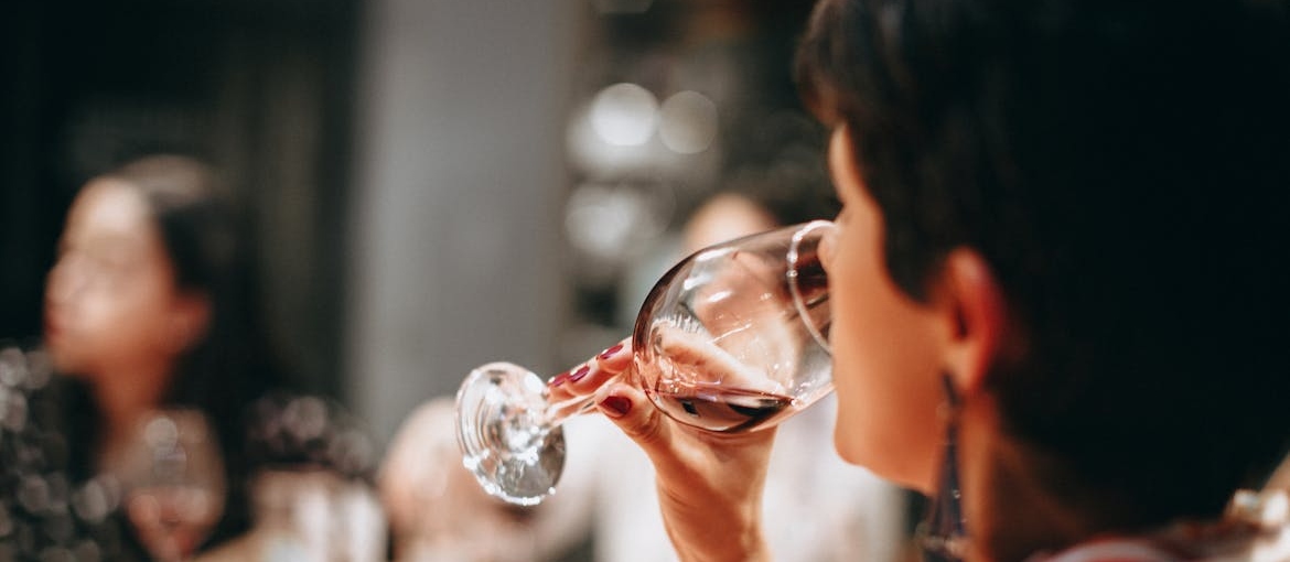 Woman drinking a glass of wine during dinner.