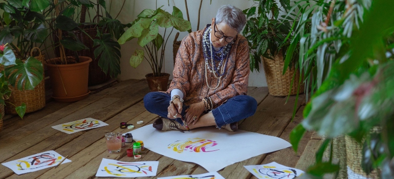 An elderly woman painting