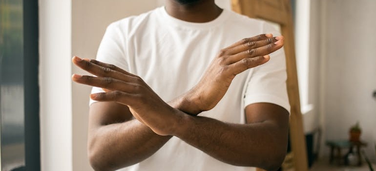 Man holding his arms in front of his body.