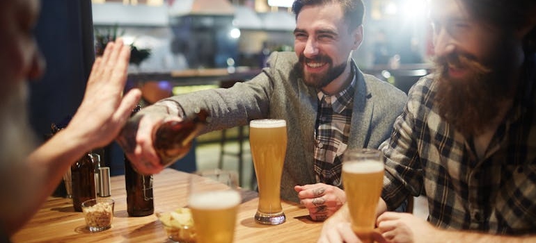 Men offering their friend a drink.