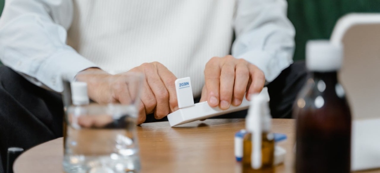 A person holding its meds in a dosette and taking it one by one