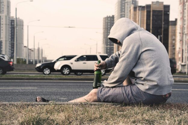 photo of a man sitting on the street showing that Men Are More Likely to Relapse