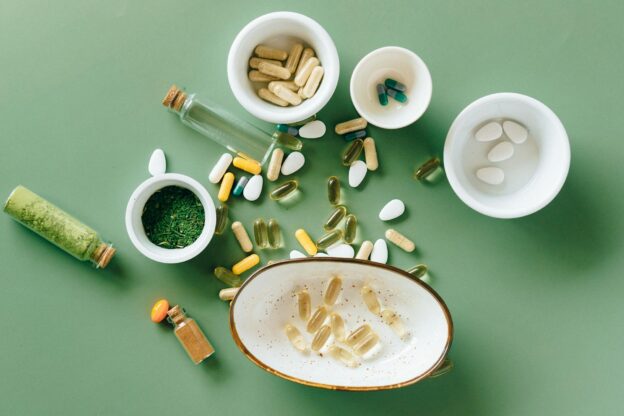 a lot of medicines on a green surface representing the Hidden Risks of DIY Drug Detox