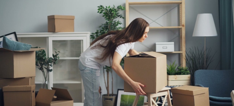 a woman moving some boxes