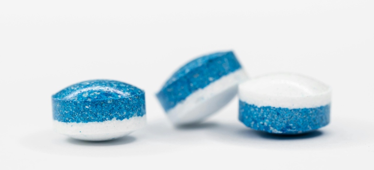 A blue and white Ecstasy pills on the white surface.