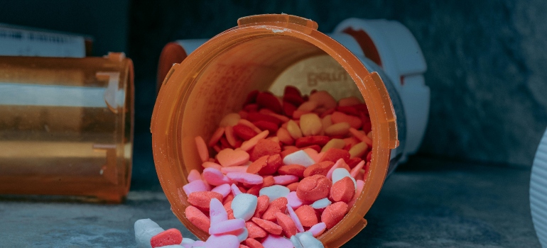 A jar of Ecstasy on the blue surface.