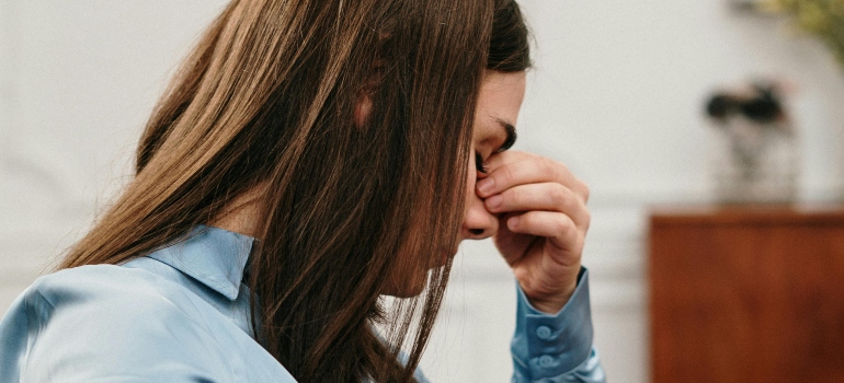A worried woman is sitting and thinking about coping with fear of failure.