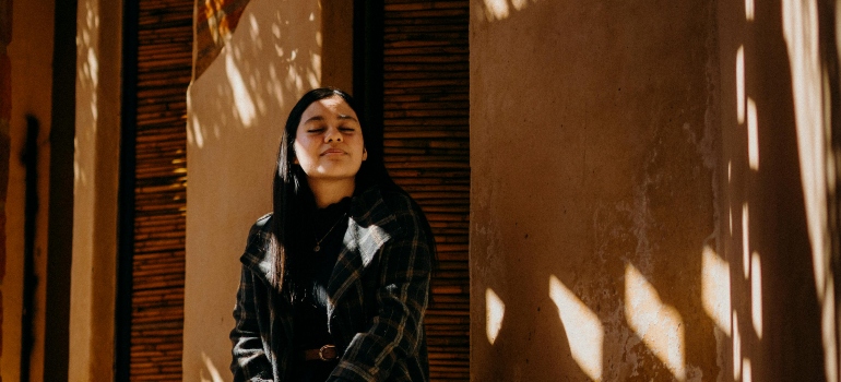 A woman is sitting outdoors and practicing mindfulness.