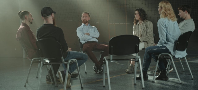 people in a support group meeting asking Can a Recovering Alcoholic Ever Drink Again