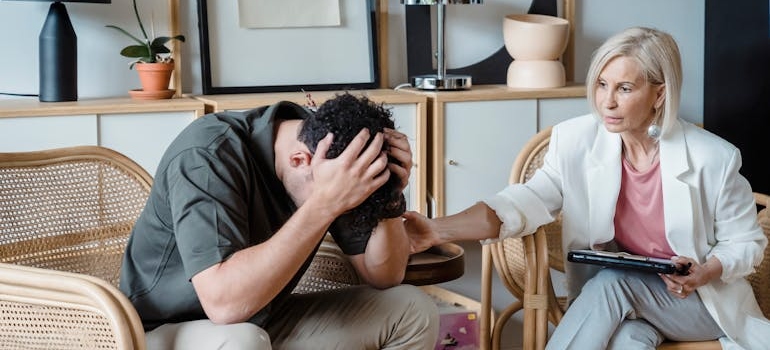 Therapist supporting her client and discussing assertiveness in recovery with him.