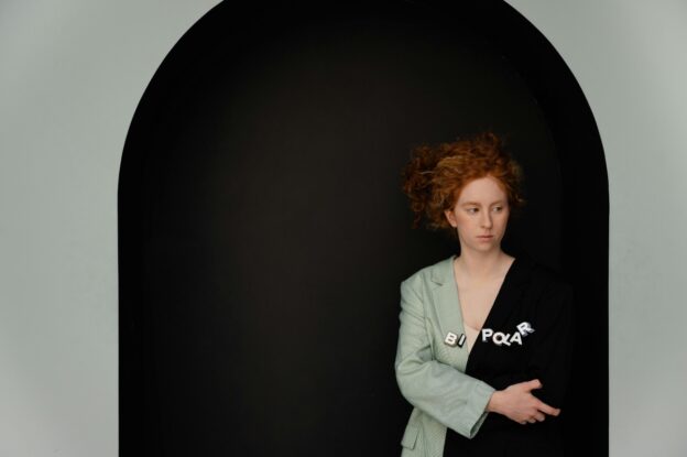 A woman is standing in front of a black and white wall.
