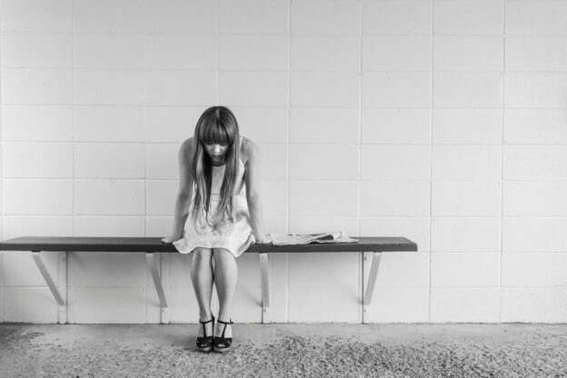 A sad woman is sitting on the bench and thinking about rehab in West Virginia.