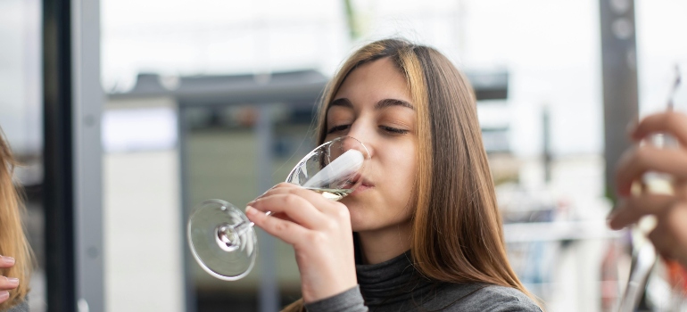 A woman is drinking alcohol with her friends.