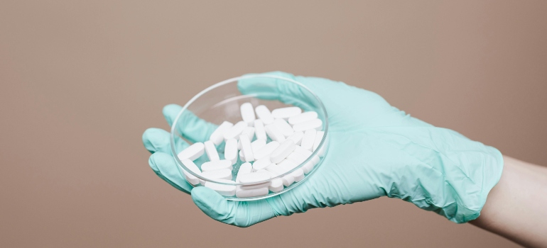 A person is holding a jar of pills with hand gloves, and thinking about "why do people take Xanax?"