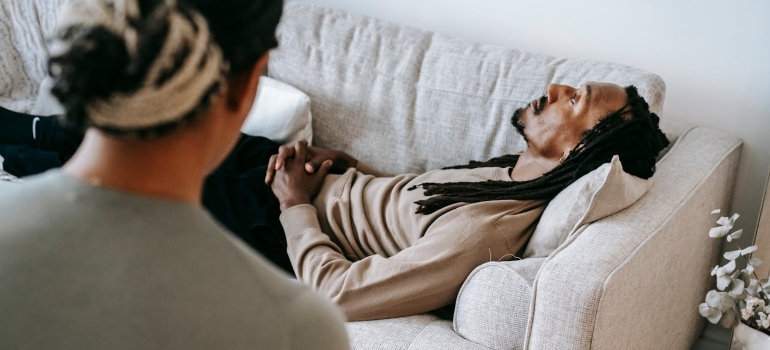a man lying on a sofa and speaking to the therapist
