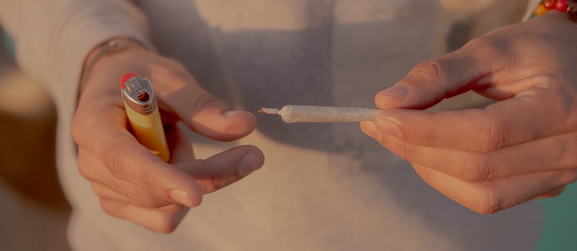 Person holding a joint and a lighter.