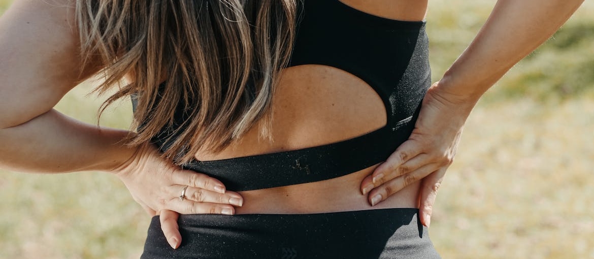Woman holding her back.