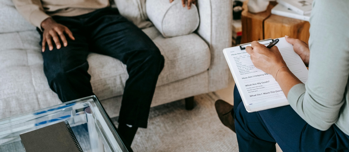 Patient sitting on a couch talking to a doctor
