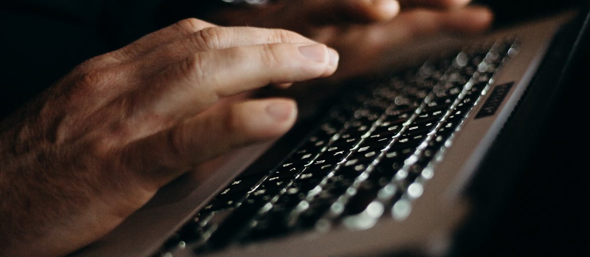 A man is searching "FAQs about addiction treatment" on his laptop.