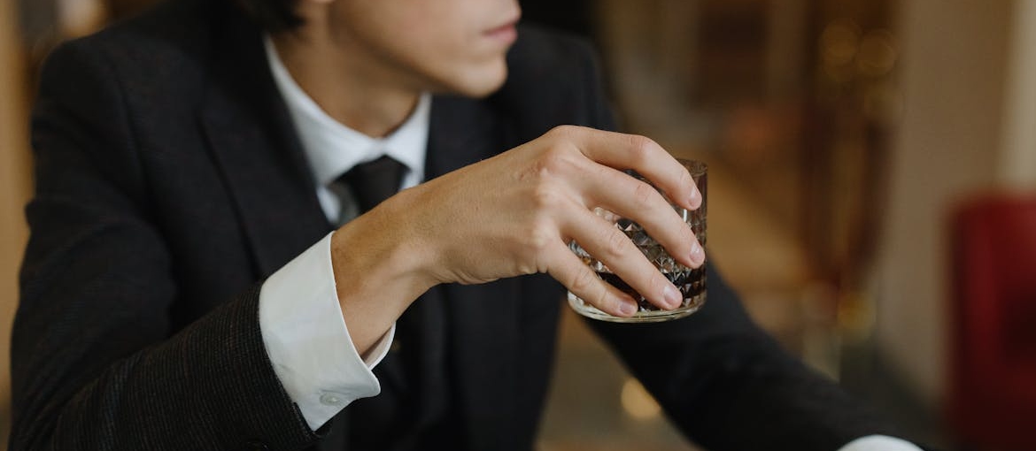 A man in suit drinking