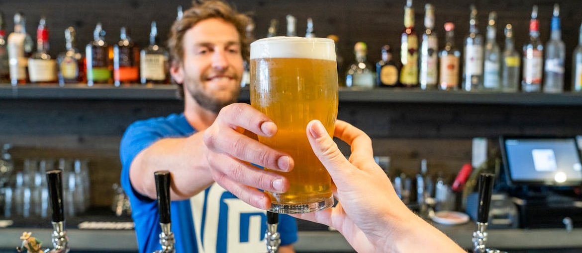 A bartender giving beer to a client.