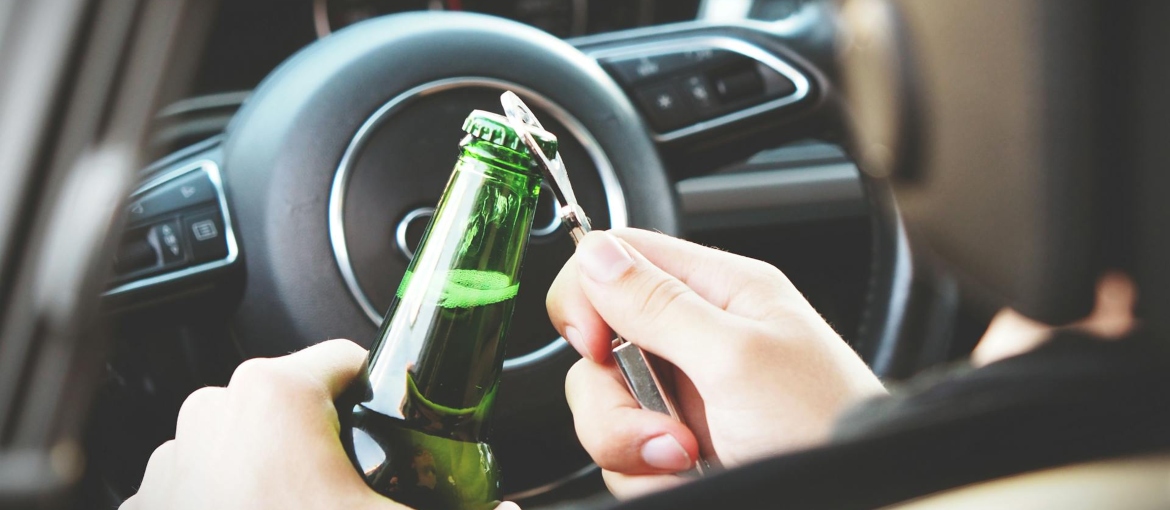 person opening bottle on car