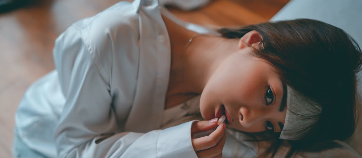 Ritalin Side Effects in Females shown in a photo of a woman taking a medicine.