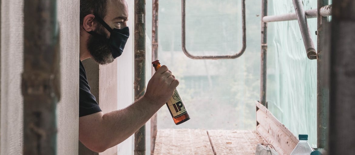 A construction worker drinking alcohol