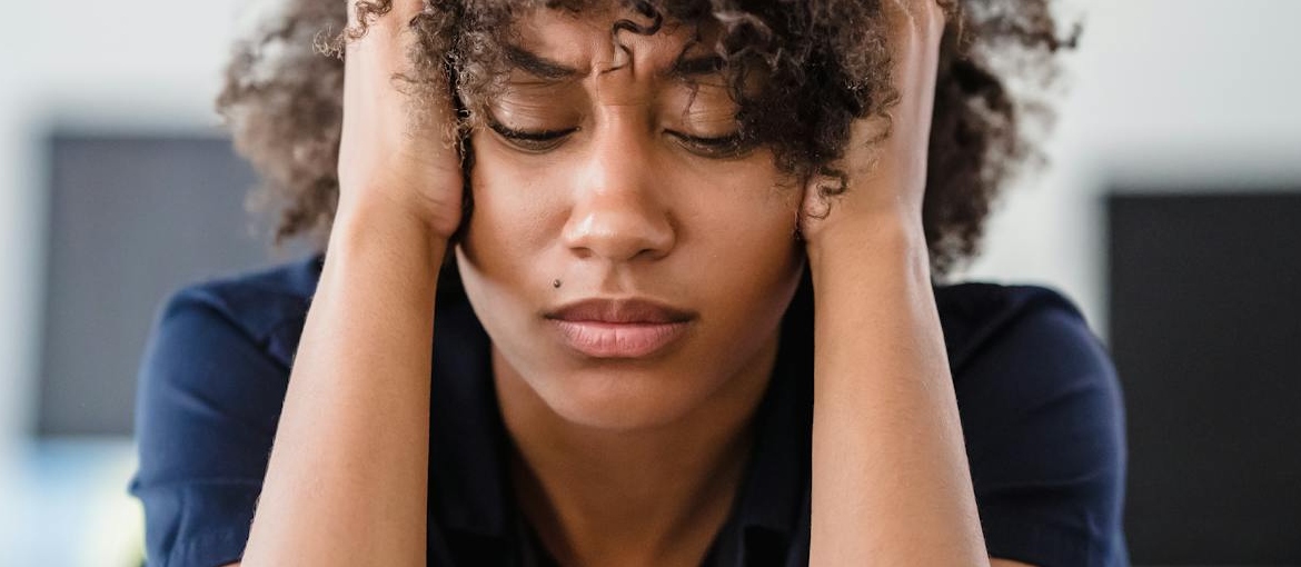 Woman holding her head while having a migraine.
