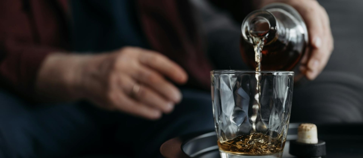 A man is pouring alcohol into a glass, and discussing "How long does it take alcohol to leave your system?"