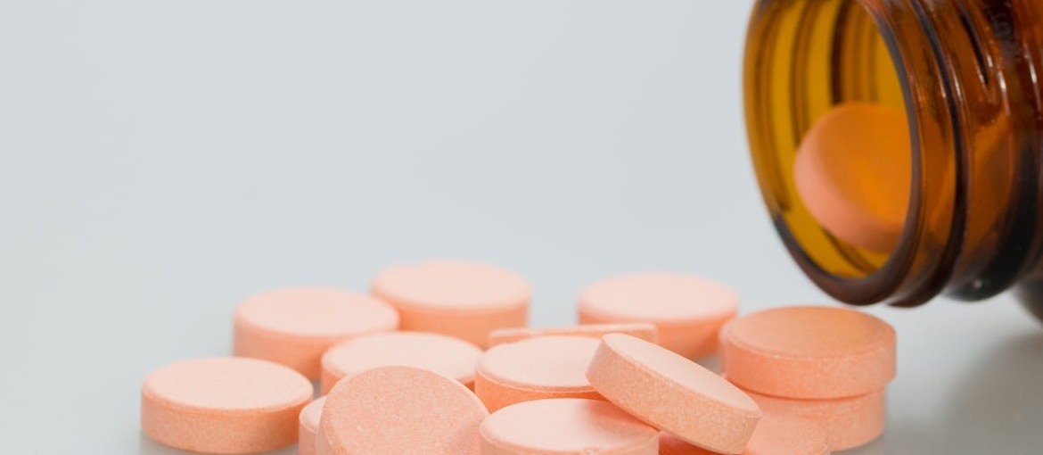 Orange pills coming out of a bottle.