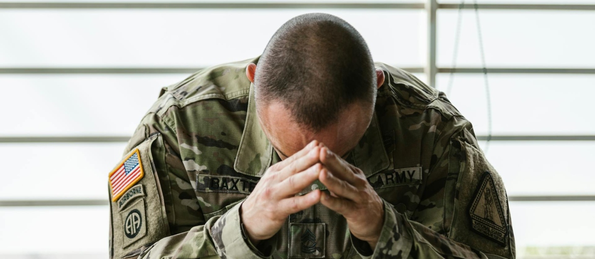 a veteran with PTSD holding hands on his head