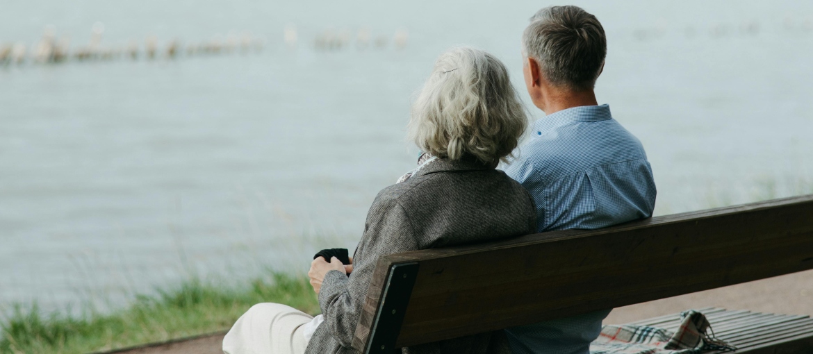 Two people are sitting on a bench and talking.