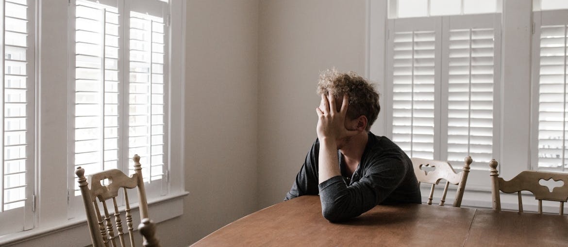A person sitting alone struggling with cocaine withdrawal symptoms