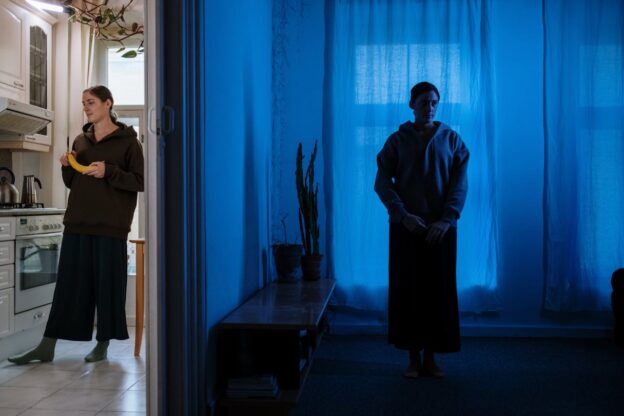 Woman standing on each side of the door.