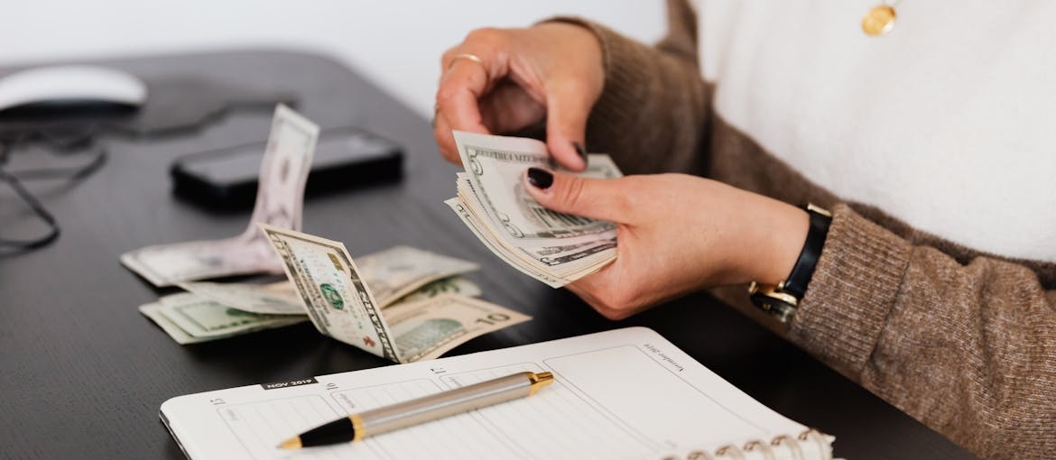 Woman counting money while making a budget.