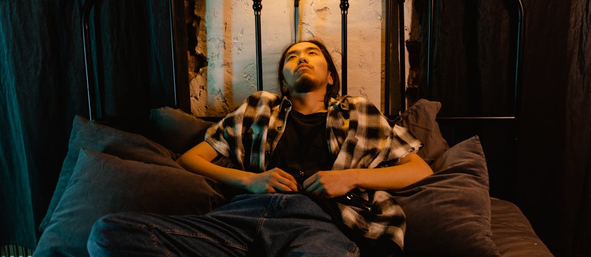 Man lying in bed looking up at the ceiling.