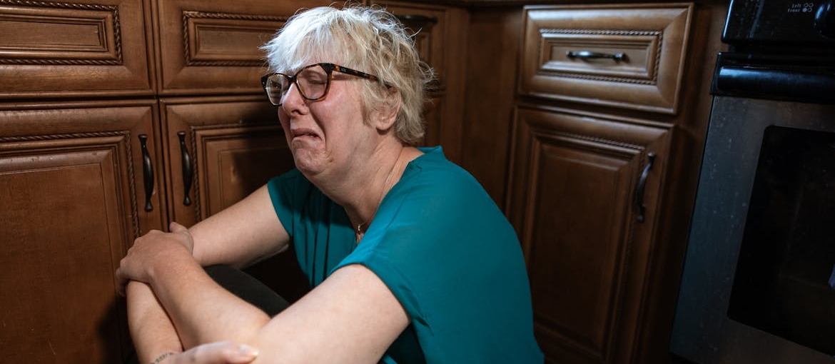 A woman crying on the floor.