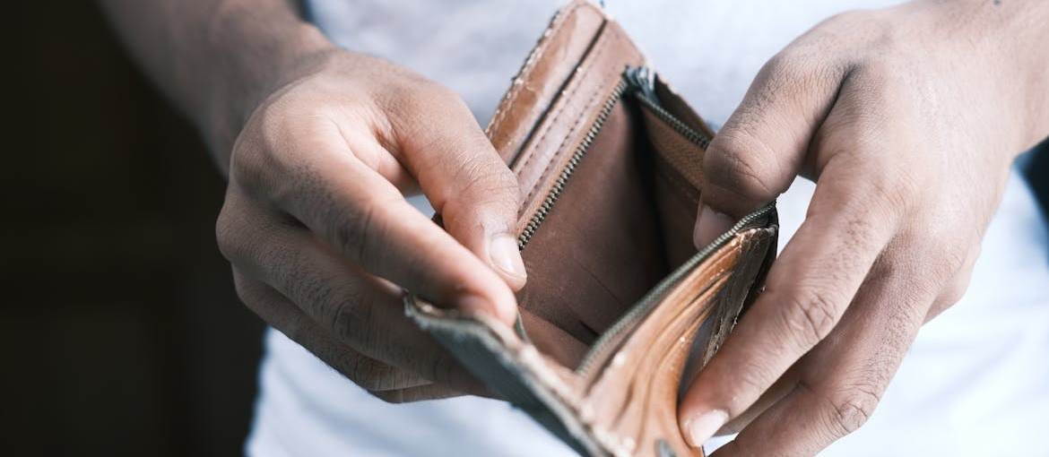 Man opening an empty wallet.
