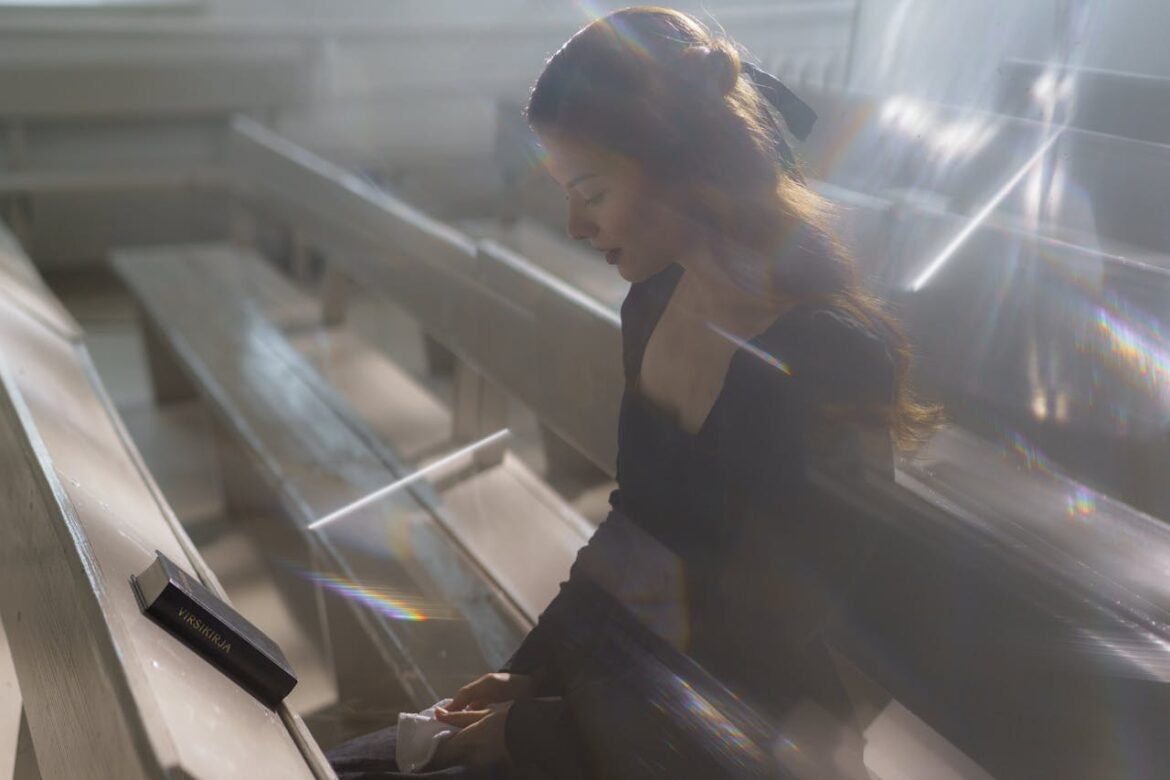 Woman sitting in the church pews and praying.