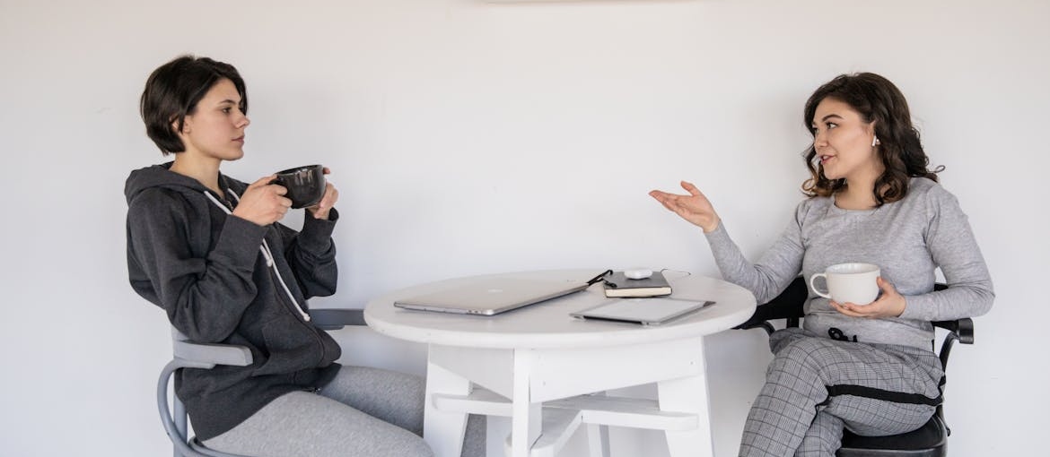 Two women drinking coffee and talking.