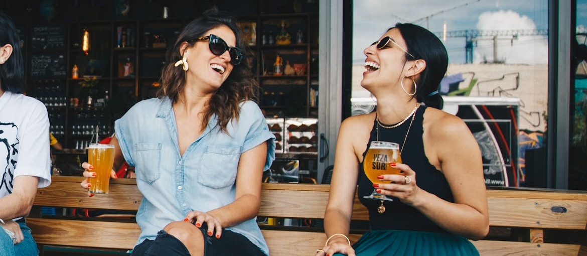 Two friends laughing and drinking beer.