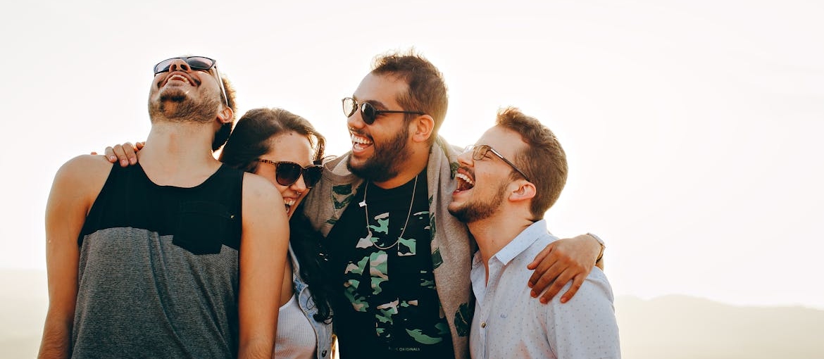 Four friends hugging and laughing.