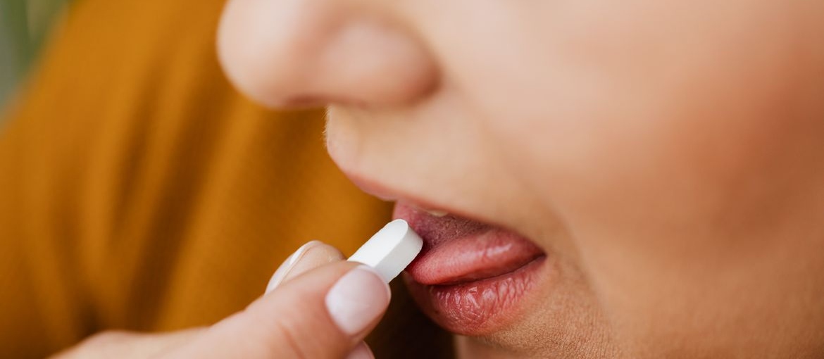 Person taking a pill.