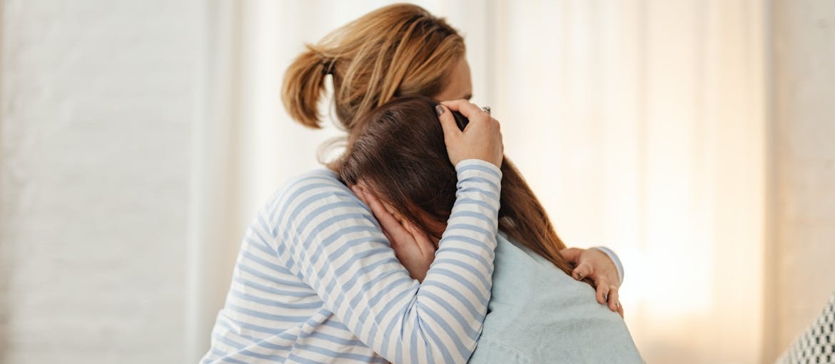 Woman hugging her daughter after talking about alcohol use disorder during alcohol awareness month.