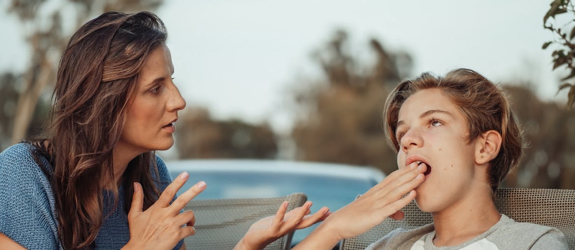 Woman talking to her son while he yawns.