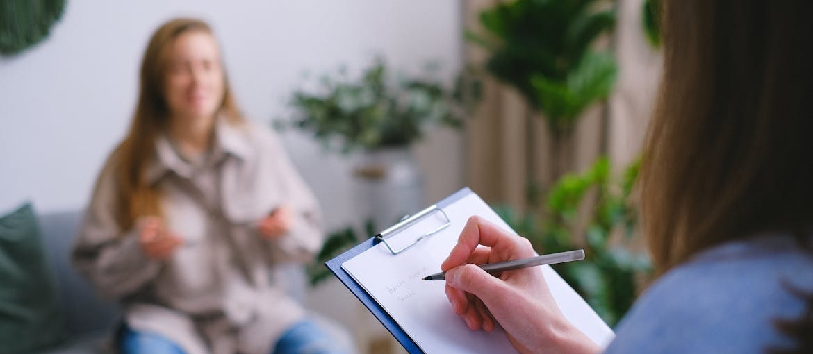 Woman talking to her therapist about telling family about drug addiction.