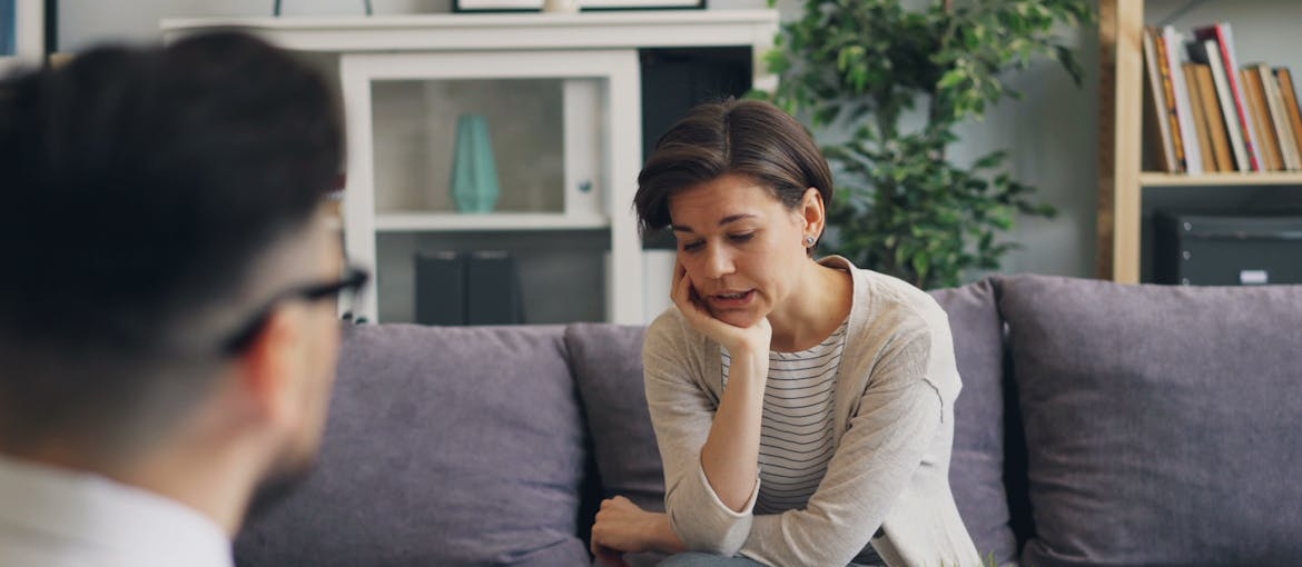 Woman talking about a loved one’s spirituality changing during recovery with a man.